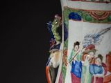 a vase with a painting on it sitting on a table