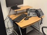 un bureau sur lequel se trouvent un ordinateur et un téléphone