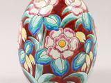 a vase with flowers painted on it sitting on a table