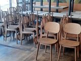 des tables et des chaises dans un restaurant, avec une grande fresque murale en arrière-plan