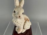 figurine of a white rabbit sitting on a wooden base