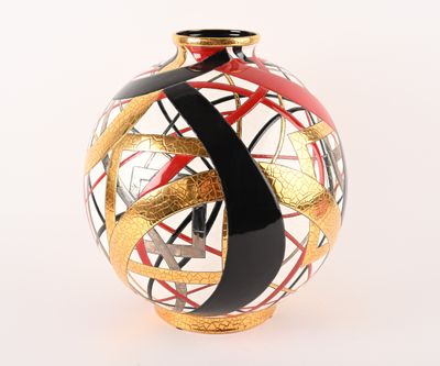 un vase noir et doré orné d'un motif rouge
