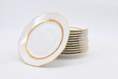 a stack of white plates with gold rims on them