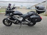 une photo d'une moto noire et argentée garée sur un parking