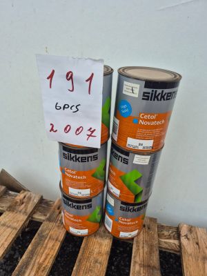 deux pots de peinture posés sur une palette en bois, à côté d'un panneau