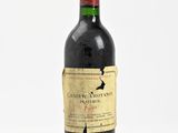 an old bottle of wine sitting on top of a white surface