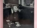 photographie en noir et blanc d'un homme embrassant une femme à une table
