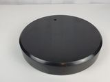 un gros plan d'un objet circulaire noir sur une surface blanche