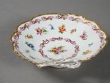 a white bowl with gold trim and flowers on it