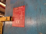 a red sign on a blue wall in a warehouse