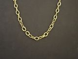 un collier à chaîne en or avec un gros maillon sur fond noir