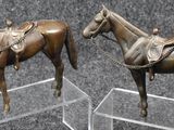 two statues of a horse and a horse with a saddle
