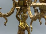 un lustre doré représentant une femme tenant une bougie