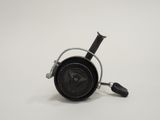 une petite horloge noire avec une poignée noire sur un fond blanc