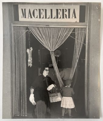 photographie en noir et blanc d'un homme et d'une petite fille debout devant un magasin