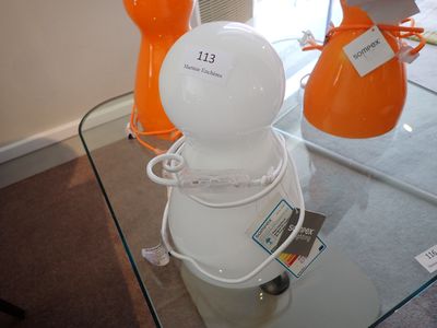 une table en verre sur laquelle sont posés des vases orange et blancs