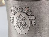a silver cup that has a monogram on it