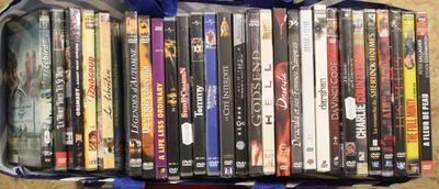 beaucoup de DVD dans un sac bleu posé par terre