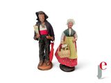 two figurines of people standing next to each other
