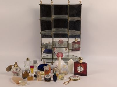 Des flacons de parfum sont disposés sur une table, avec un miroir en arrière-plan.