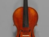 an old violin sitting on top of a gray surface