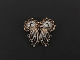 une broche en or et diamants sur un fond noir