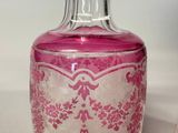 a pink glass bottle with a pink design on it