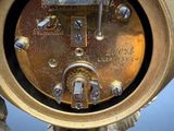 a gold clock that is sitting on a table