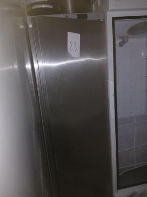 un réfrigérateur en acier inoxydable dont la porte est ouverte, dans une cuisine