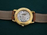 a close up of a watch on a green surface