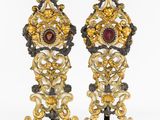 paire de bougeoirs en verre doré et rouge reposant sur des socles en marbre noir