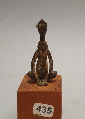 a small statue of a monkey sitting on a block