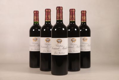 quatre bouteilles de vin rouge sont alignées sur une table