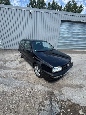 La voiture noire est garée devant un garage.