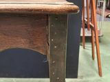 a small table with a wooden top on a green floor