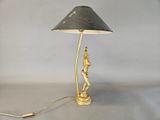 brass table lamp with a black shade and a statue on the base