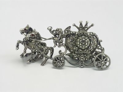 silver plated figurine of a horse drawn carriage with a man on it
