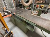 a machine that is cutting a piece of wood in a factory