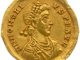 a close up of a gold coin with a woman on it