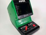 un appareil électronique vert et noir posé sur une surface blanche