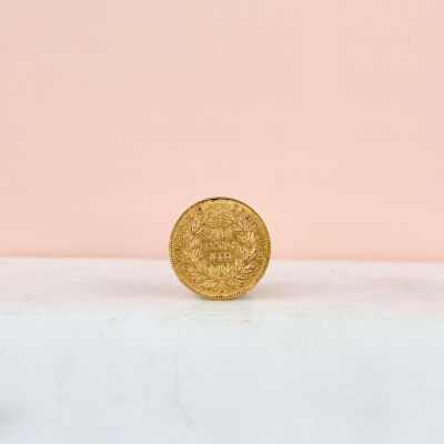 a gold coin sitting on top of a white surface