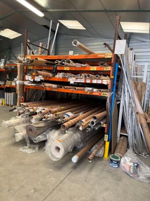 de nombreux rouleaux de tissu et de bois dans un entrepôt
