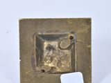 an image of a small brass plate with a tag on it