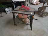 une table sur laquelle est posée une scie, dans un garage