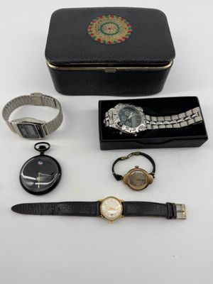 an assortment of watches and a watch case on a table