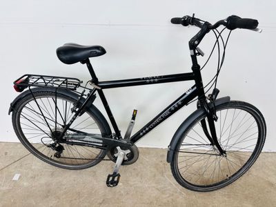 un vélo noir garé contre un mur dans un garage