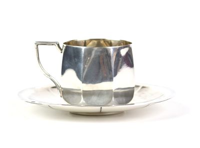 une tasse et une soucoupe en argent posées sur une soucoupe