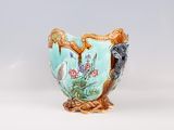 a blue vase with a bird and flowers on it