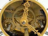a gold clock with a white face and black hands