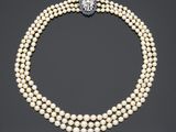 un collier de perles à trois rangs muni d'un fermoir en diamant